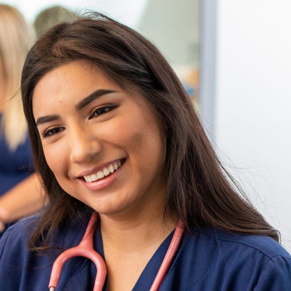 Female nursing student listening to someone talking.