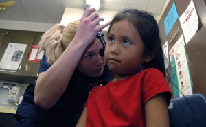 Nursing student examining young girl