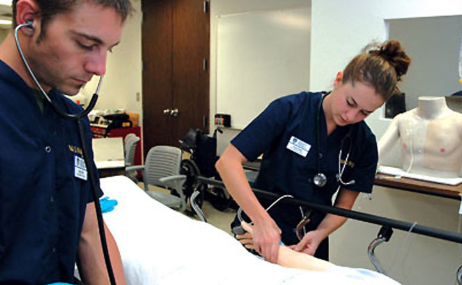 Two students caring for patient