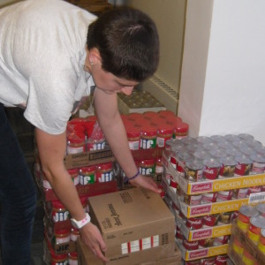 NAU student stacks boxes in Louies cupboard