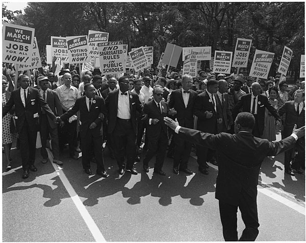 Civil rights marchers parade down the street.