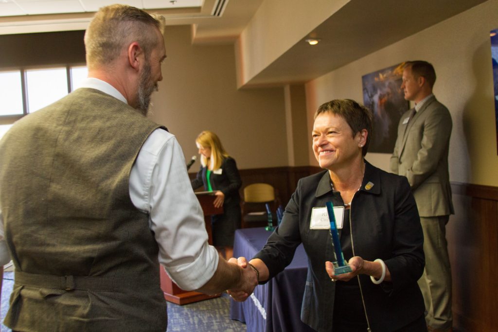 NAU President Rita Cheng smiles and shakes the hand of Tim Darby