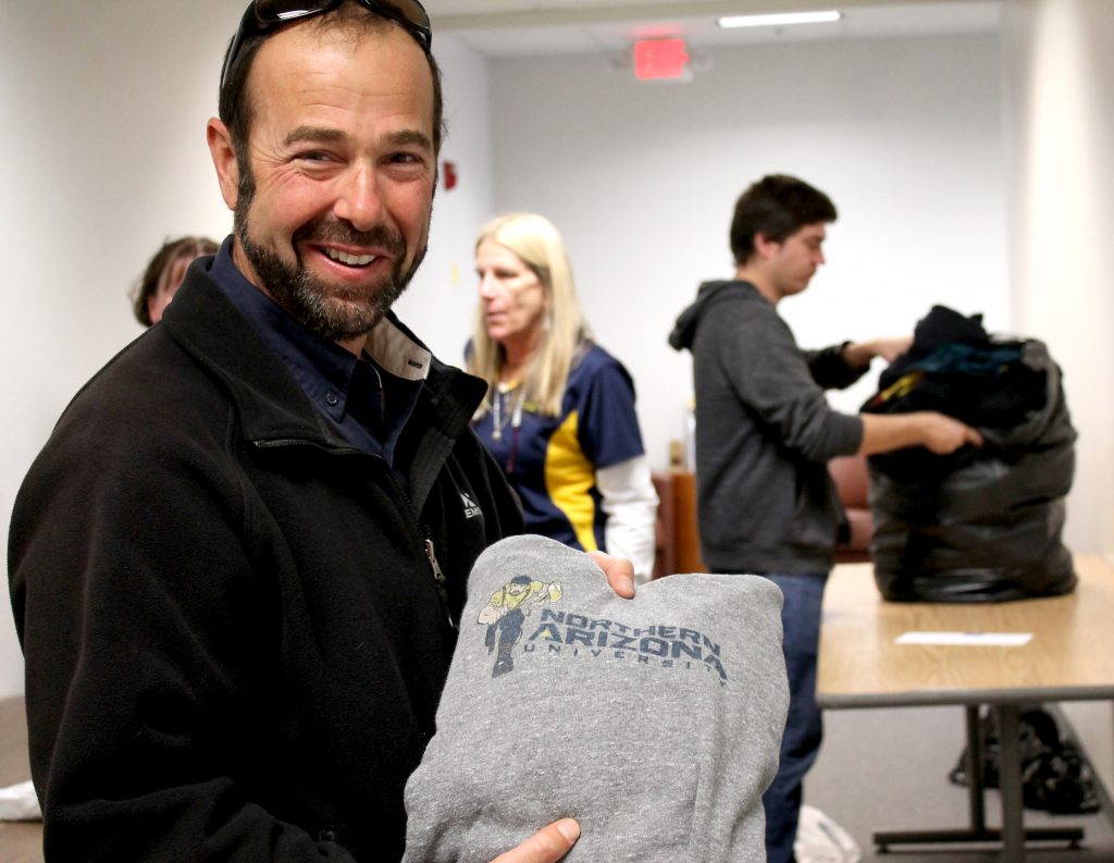 Scott Halle holds up donated NAU shirt