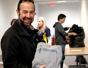 Scott Halle holds up donated NAU shirt