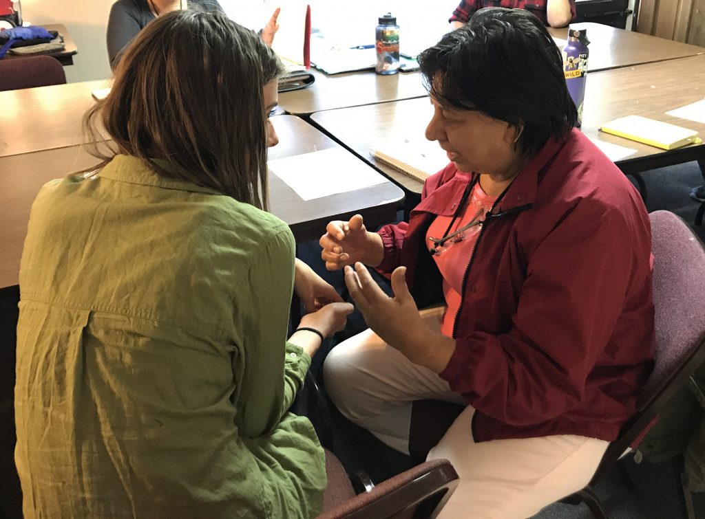 CUPI member Hannah Roberts speaks with NAIC leader Maria de Jesus Guillen at an NAIC immigration team meeting