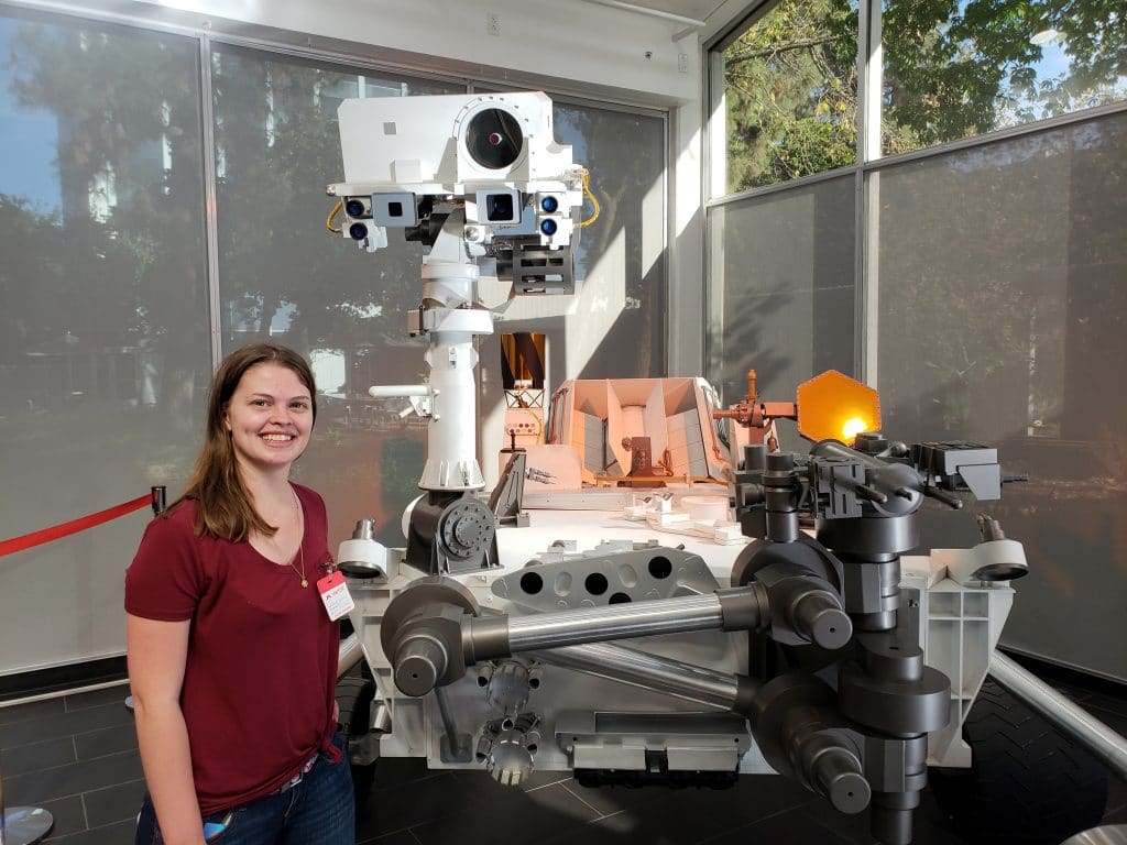 Lamm standing with replica model of Curiosity rover