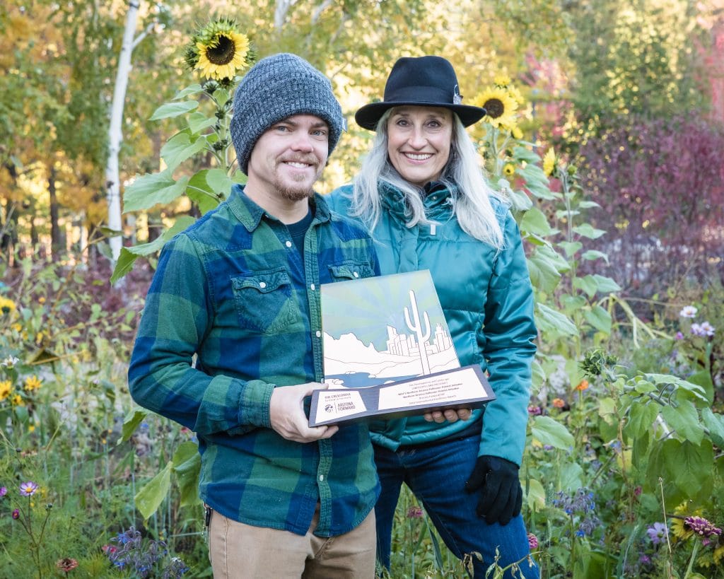 Tyler Linner (left) and Jocelyne Shiner of NAZPHI, standing among Autumn flowers in the SSLUG Garden on south campus.