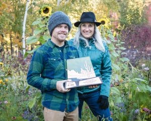 Tyler Linner (left) and Jocelyne Shiner of NAZPHI, standing among Autumn flowers in the SSLUG Garden on south campus.