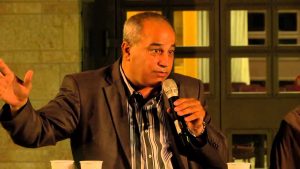 Moahmmad Darawshe speaks into a microphone while presenting to his audience
