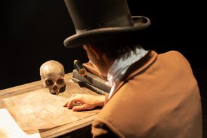 Dr. Frankenstein examines a map with a skull on it