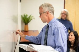 Michael McCarthy writes on a whiteboard.