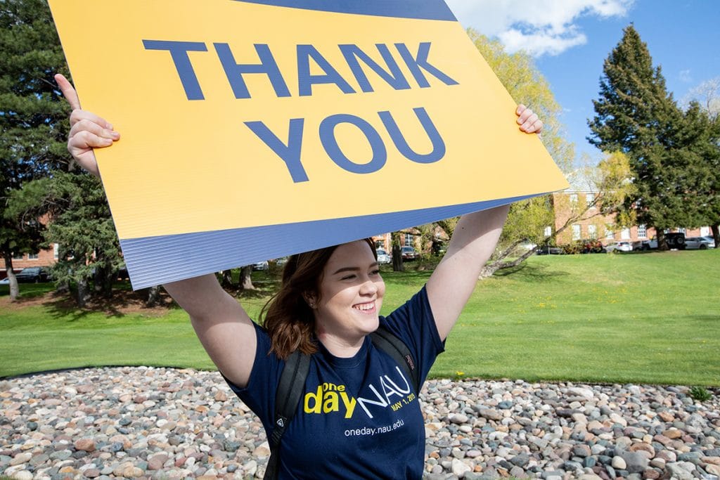 student holds a thank-you sign