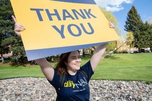 student holds a thank-you sign