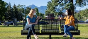 Masked students sit on bench