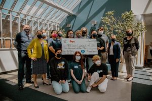 Louie's Cupboard and Fry's representatives pose with check