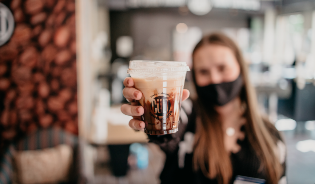 NAU student holds up coffee cup