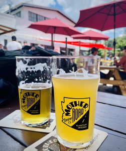 two pint glasses of beer on an outside patio table
