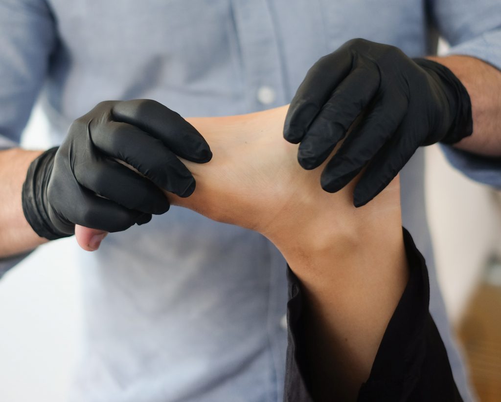 A physical therapist works on a person's foot.