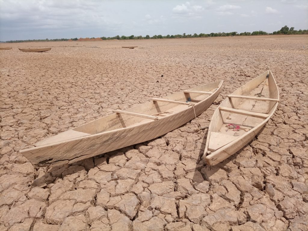 Canoes sit on dry lakebed.