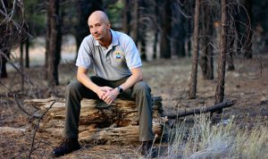 James Jensen sits on log