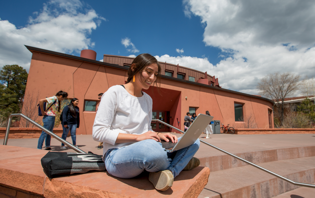 Student outside NACC on laptop