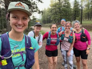 Esther Cuellar and other women in running gear smile at the camera.
