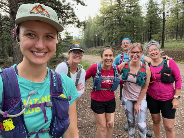 Esther Cuellar and other women in running gear smile at the camera.