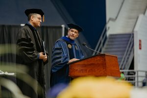 Dom Flemons and President Cruz Rivera in graduation robes at spring commencement