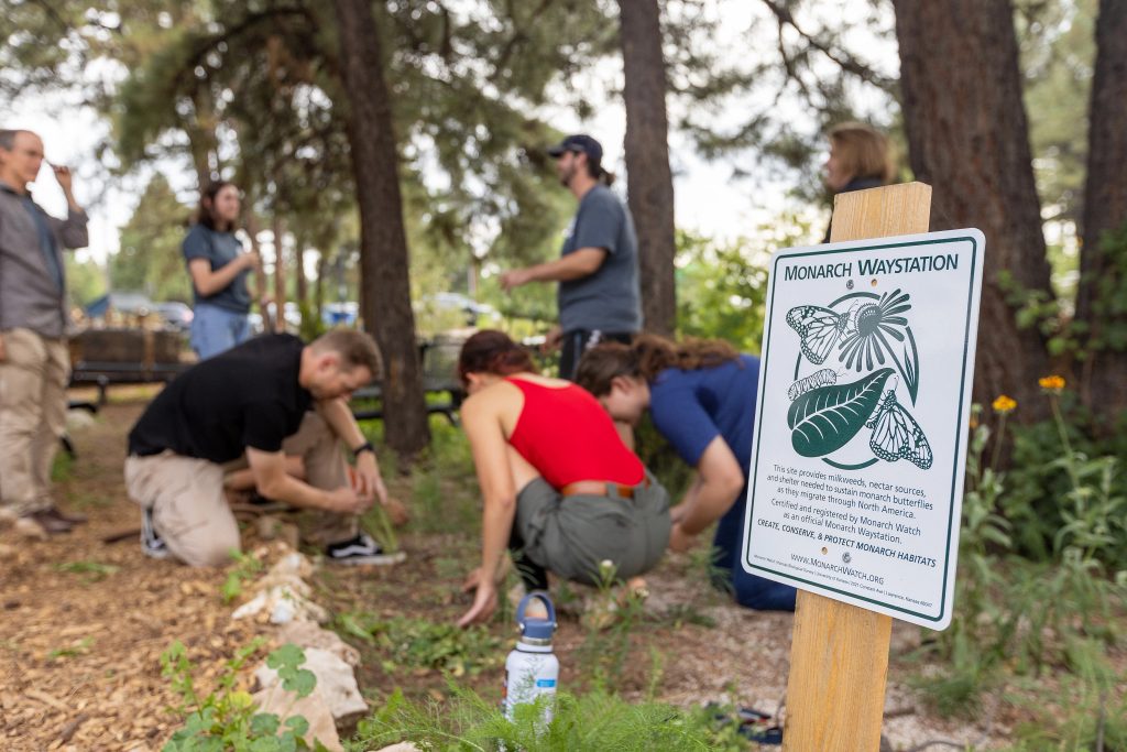 Monach Waystation sign with students in the background