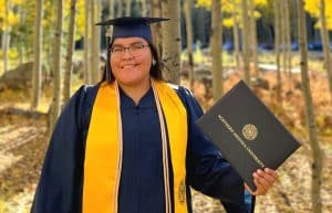 Nicole Pablo in graduation robes in the aspens