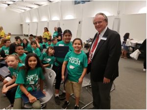 Russell Prust standing with elementary school children at an "I Am Going to College" event