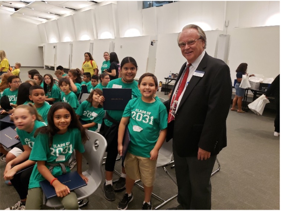Russell Prust standing with elementary school children at an "I Am Going to College" event