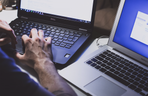 Guy types on laptop