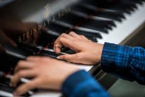 Close up of hands playing Steinway piano