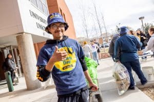 A student in a Giving Day shirt gives a thumbs up.