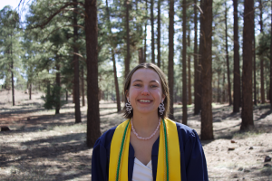 Sophia Swainson in graduation robes in the forest