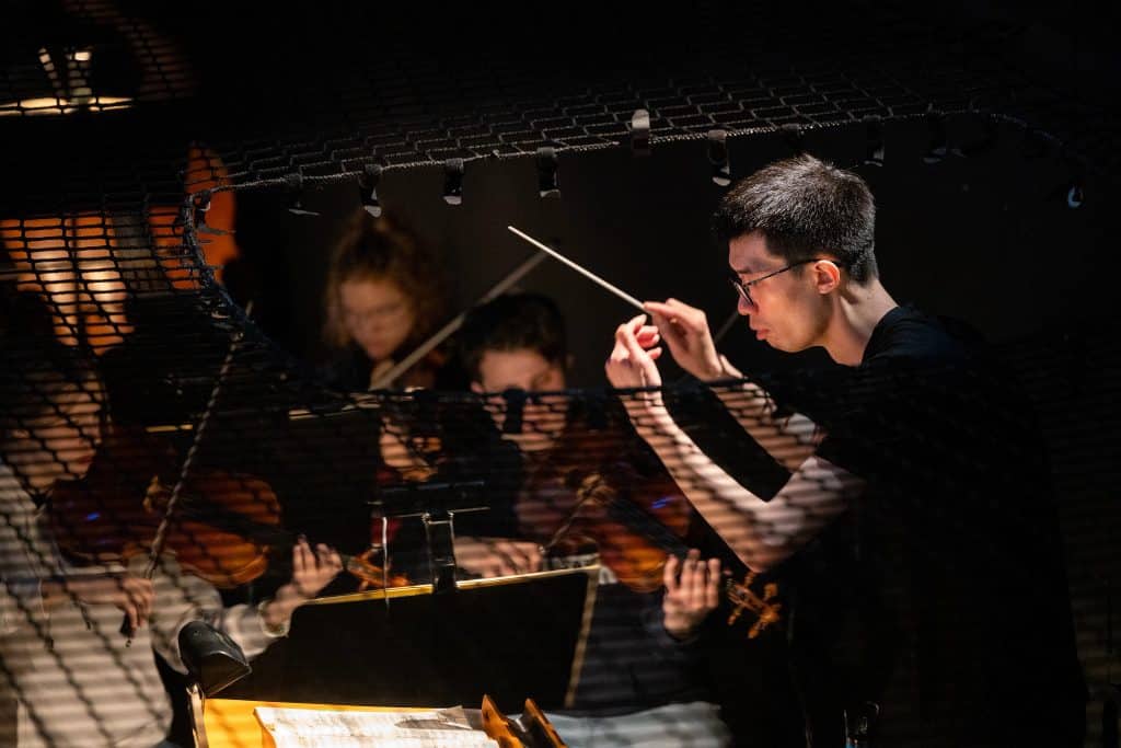 Conductor with muscians in the background