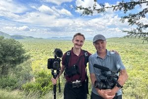 Carter and Rodriguez pose in front of Africa landscape