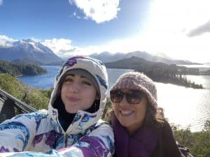 Maria Emilia Machelor and her mother in winter clothes with a lake in the background.