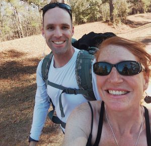 Afton McKusick and a man out hiking in the forest.