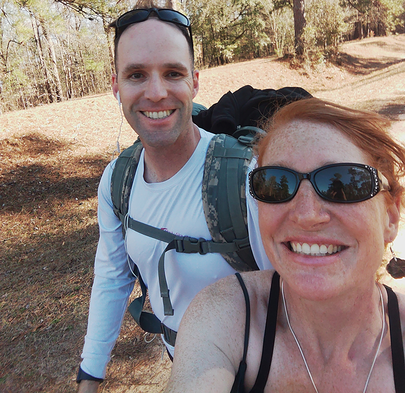 Afton McKusick and a man out hiking in the forest.