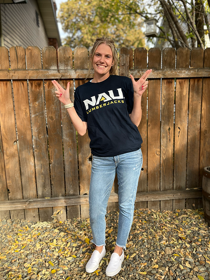 Monica Cowbrough wearing an NAU shirt doing LJs in her backyard.