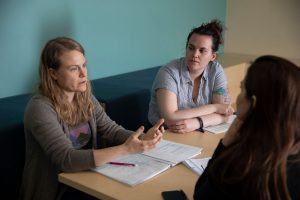 Researchers sit around a table at a workshop.