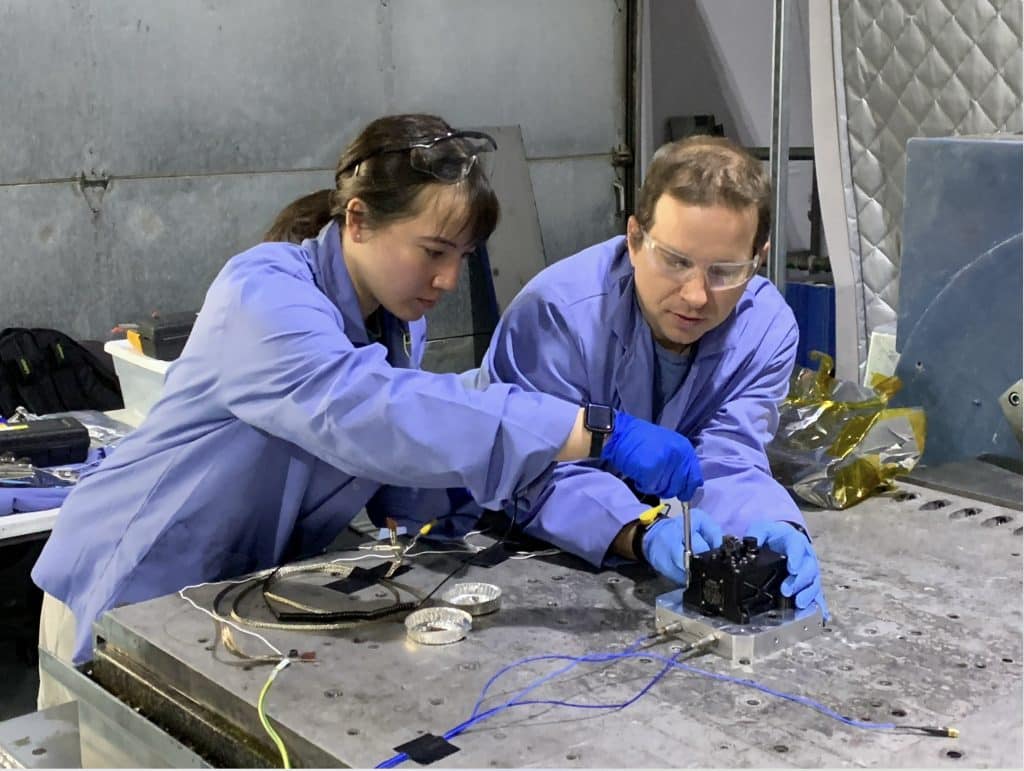 Laura Lee and Christopher Edwards work in a lab wearing PPE.