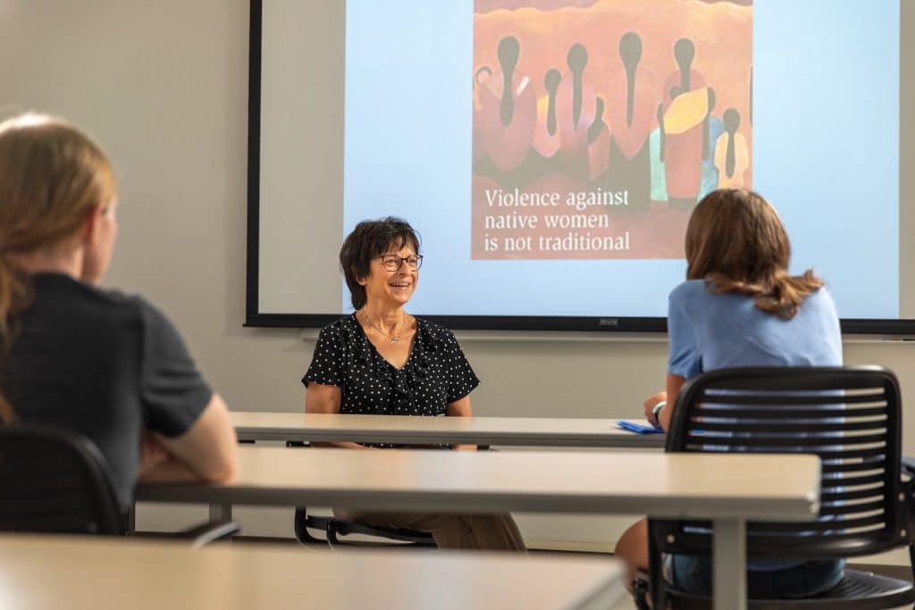 Linda Robyn giving a presentation on violence against Native women in a classroom