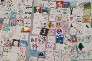 squares of 2 by 2 inch fabric with colorful drawings and writing