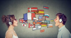 A graphic showing two people speaking to each other with different countries' flags in between, indicating their speaking in different languages.