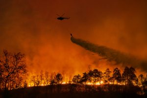 A helicopter dropping fire retardant on a California wildfire
