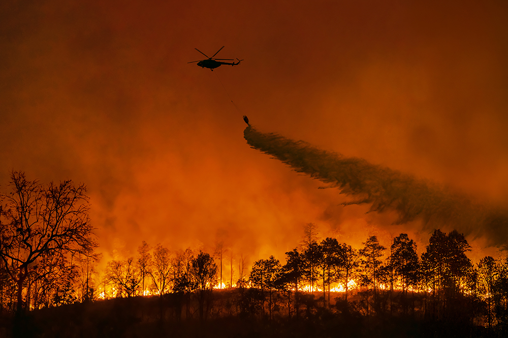 A helicopter dropping fire retardant on a California wildfire