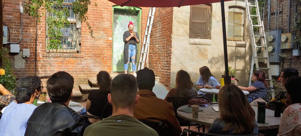 People sitting outdoors at the NOAZBF listening to an author